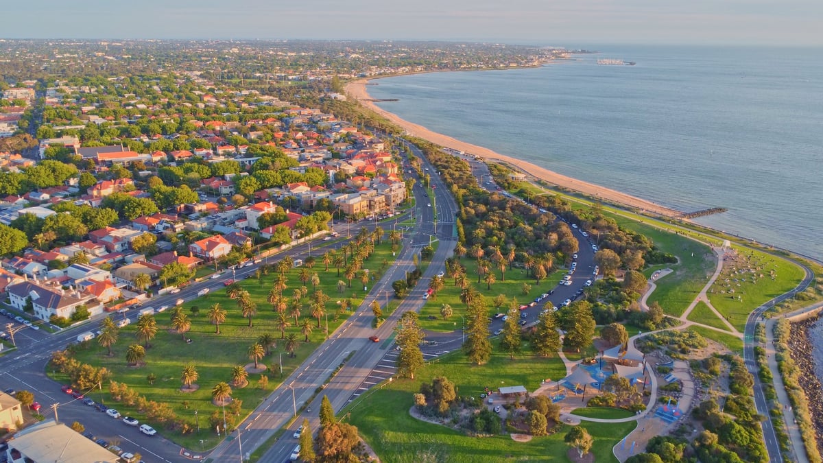Aerial view of a coastal city with palm-lined boulevards and residential areas